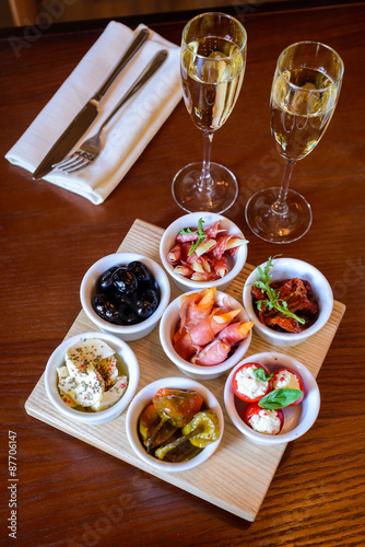 Fotografija Tasty snacks and champagne on a wooden table in a restaurant/Snacks pickles, veg