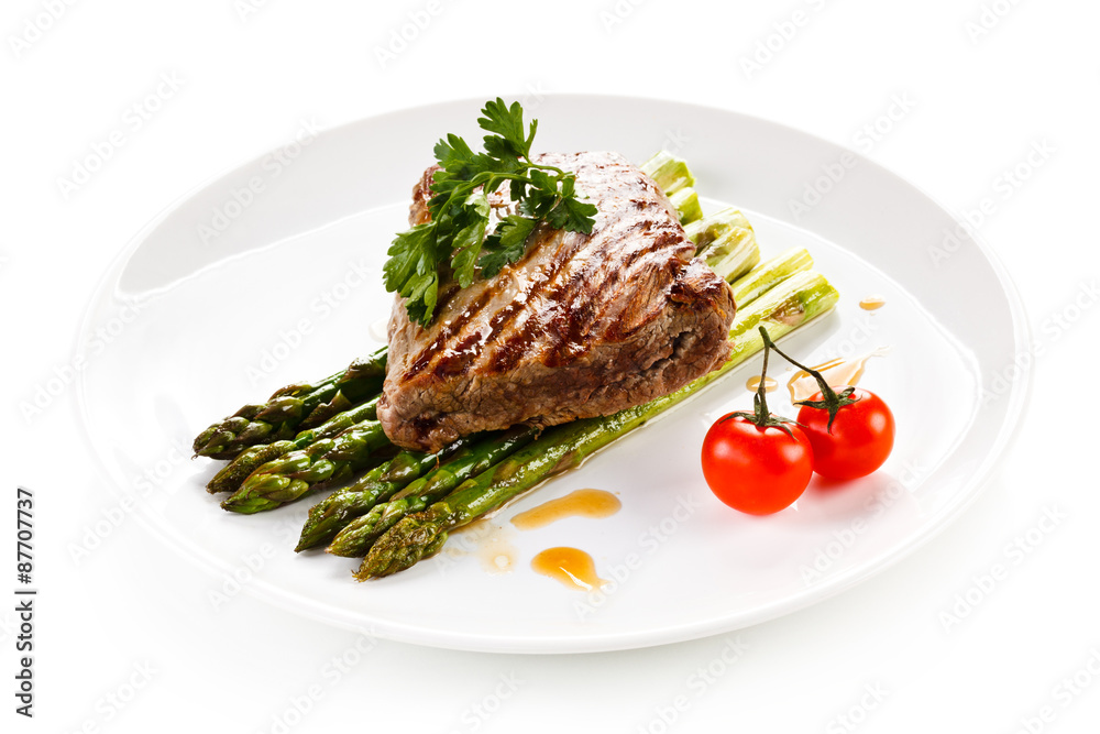 Grilled beefsteak and asparagus on white background Grilled beefsteak and asparagus on white background