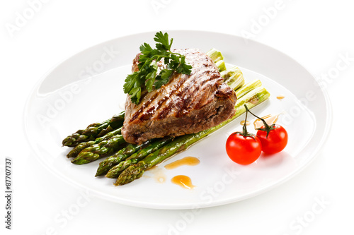 Grilled beefsteak and asparagus on white background