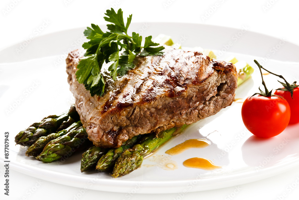 Grilled beefsteak and asparagus on white background Grilled beefsteak and asparagus on white background