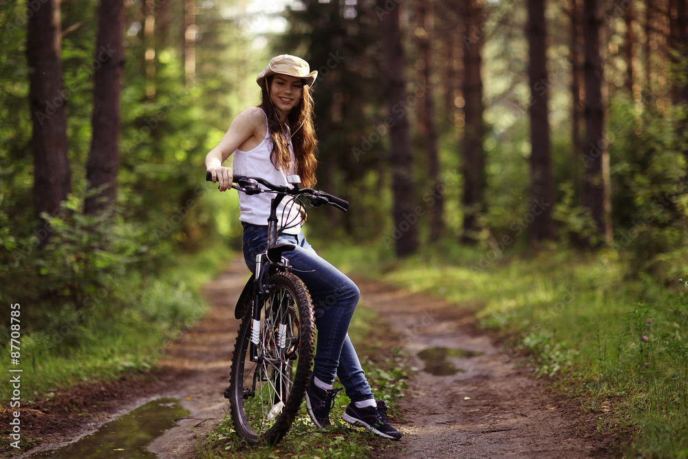 young girl on a sports bike in a summer forest young girl on a sports bike in a summer forest