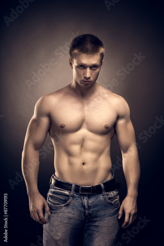 Healthy muscular young man posing in studio