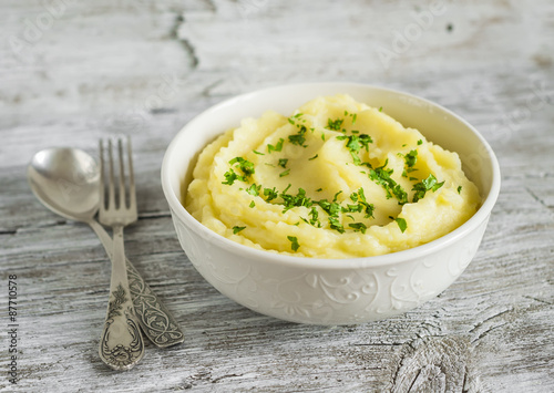 mashed potatoes in a white bowl on a light wooden background