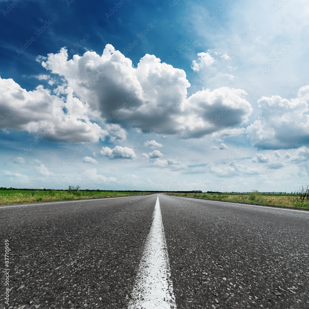 asphalt road with white line on center under dramatic sky and cl asphalt road with white line on center under dramatic sky and cl
