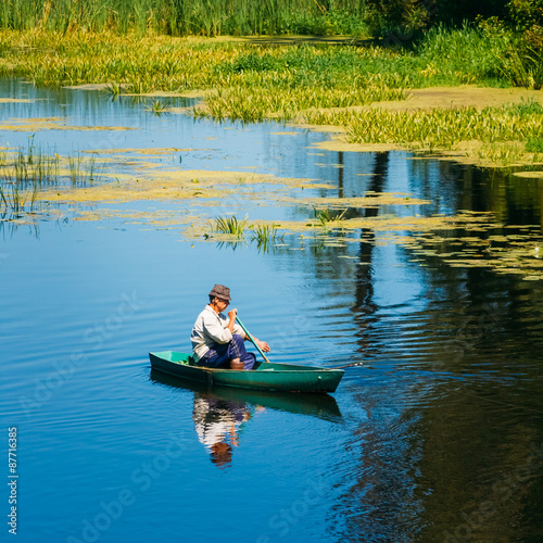 Canvas Print Elderly Man Fishing On River Boat