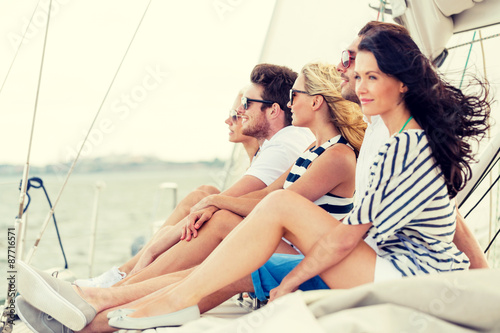 smiling friends sitting on yacht deck