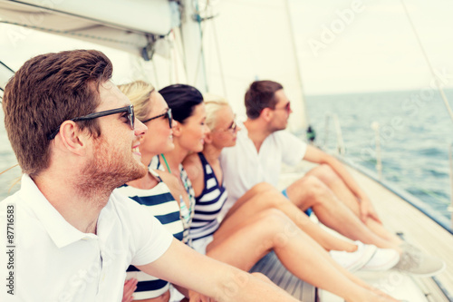 smiling friends sitting on yacht deck