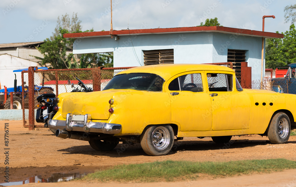 Kuba Havanna gelber Oldtimer parkt vor einem Haus