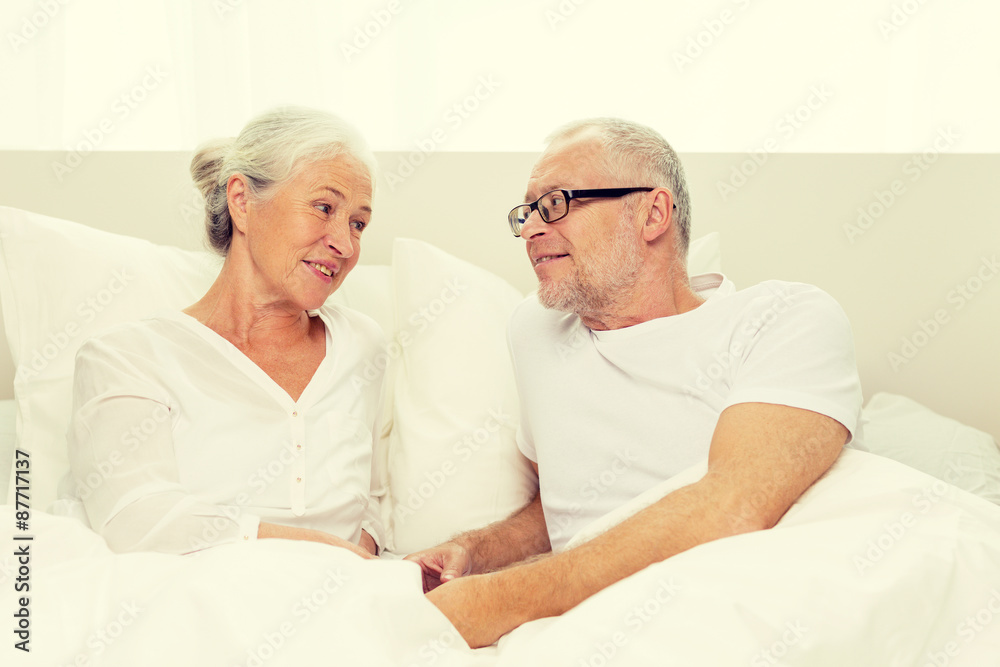 happy senior coupler lying in bad at home happy senior coupler lying in bad at home
