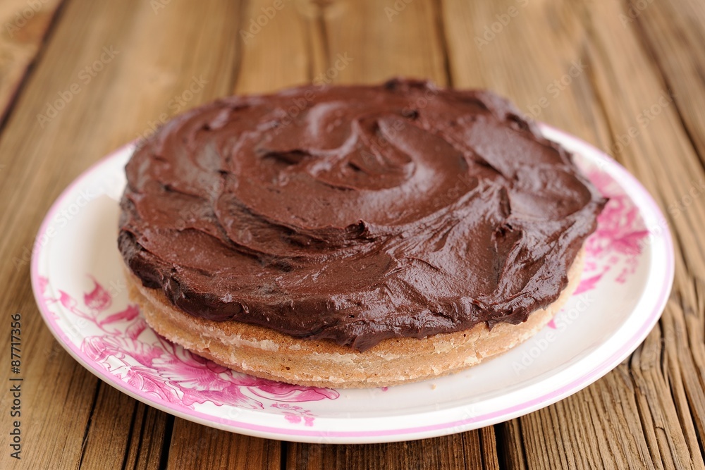 Round homemade delicious chocolate cake covered with thick ganac Round homemade delicious chocolate cake covered with thick ganac