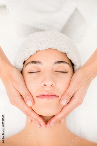 Attractive woman receiving facial massage at spa center