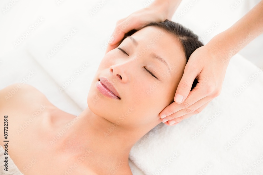 Attractive young woman receiving head massage at spa center Attractive young woman receiving head massage at spa center