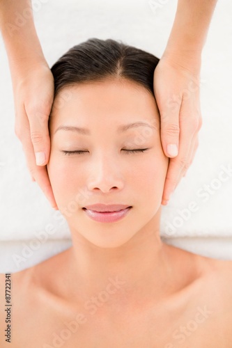 Attractive young woman receiving head massage