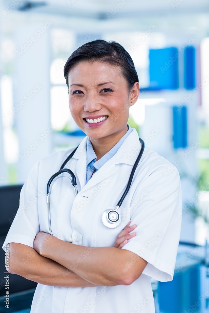 Confident doctor with arms crossed smiling at camera Confident doctor with arms crossed smiling at camera