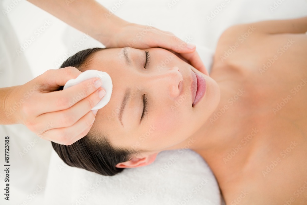 Hands cleaning woman face with cotton swabs