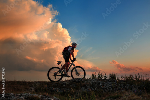 Fototapeta Naklejka Na Ścianę i Meble -  Silhouette of a biker and bicycle on sky background.