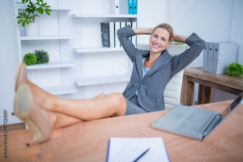 Φωτογραφία Smiling blonde businesswoman relaxing herself