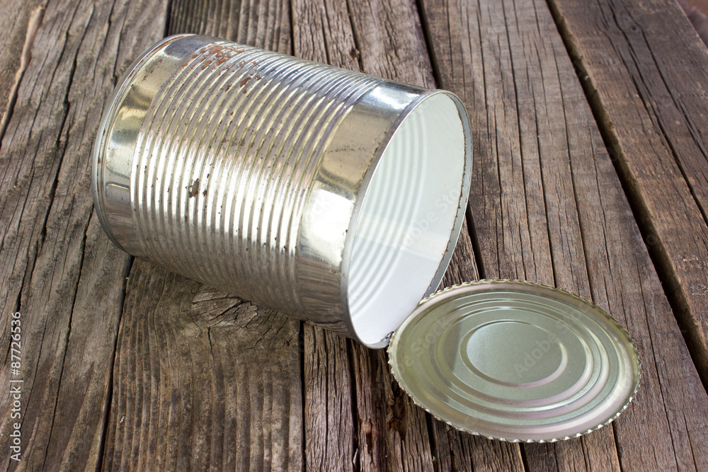 Open empty tin can on wooden background Open empty tin can on wooden background