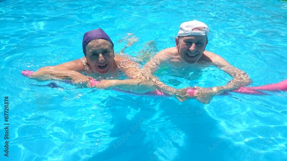 Abuelos sonriendo en la piscina
