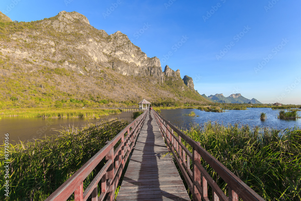 Fototapeta premium Wooden Bridge in lotus lake on sunset time at Khao Sam Roi Yot National Park, Thailand