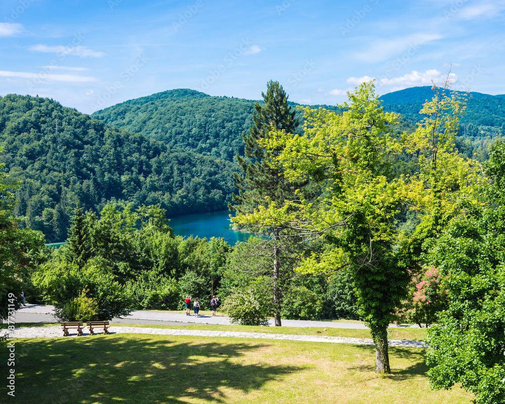 Landscape of Plitvice Lakes with tourists. Sunny day.