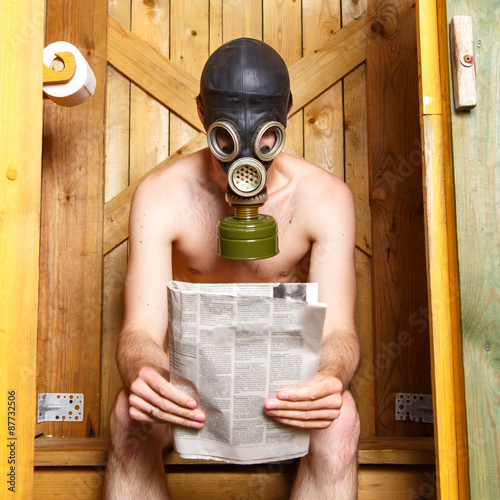 Φωτογραφία Nude man in gas-mask sitting in stinky toilet in Finland