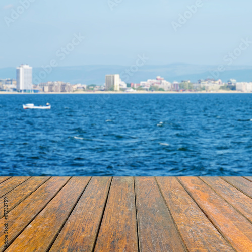 Empty wooden table for product presentation. In the background blurred large beach resort