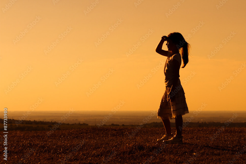 Little girl enjoys in sunset