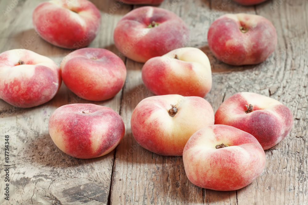 Flat pink peach on an old wooden background, selective focus Flat pink peach on an old wooden background, selective focus