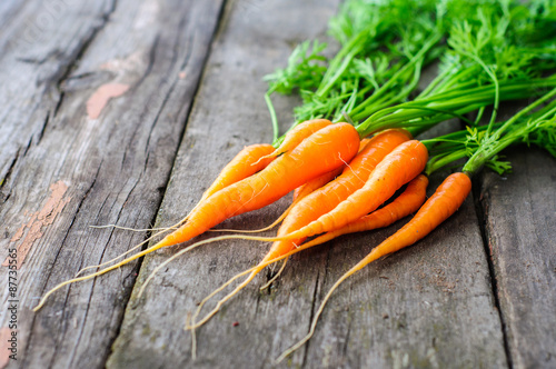 Bunch of fresh washed carrot on the old wooden background