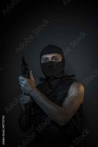Man wearing balaclavas and bulletproof vest with firearms