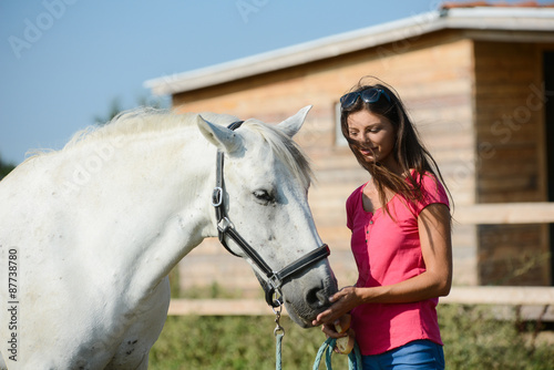 attractive young woman with a beautiful camargue white and gray horse