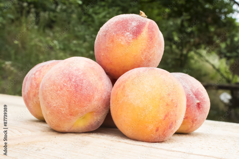 bunch of ripe juicy peaches on a wooden table bunch of ripe juicy peaches on a wooden table
