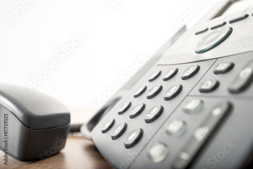 Close up angled view of a black landline telephone with a number photo