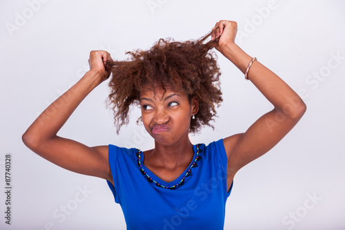 Canvas Print Young African American woman holding her frizzy afro hair - Blac