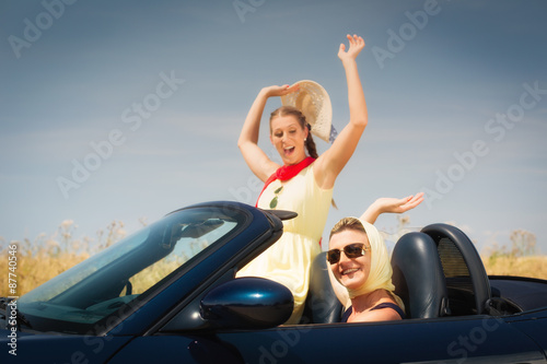 Frauen fahren im Cabrio auf Sommer Auto Ausflug und genießen ihre Freiheit © Kzenon