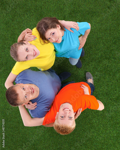 Group of young people standing on green grass 