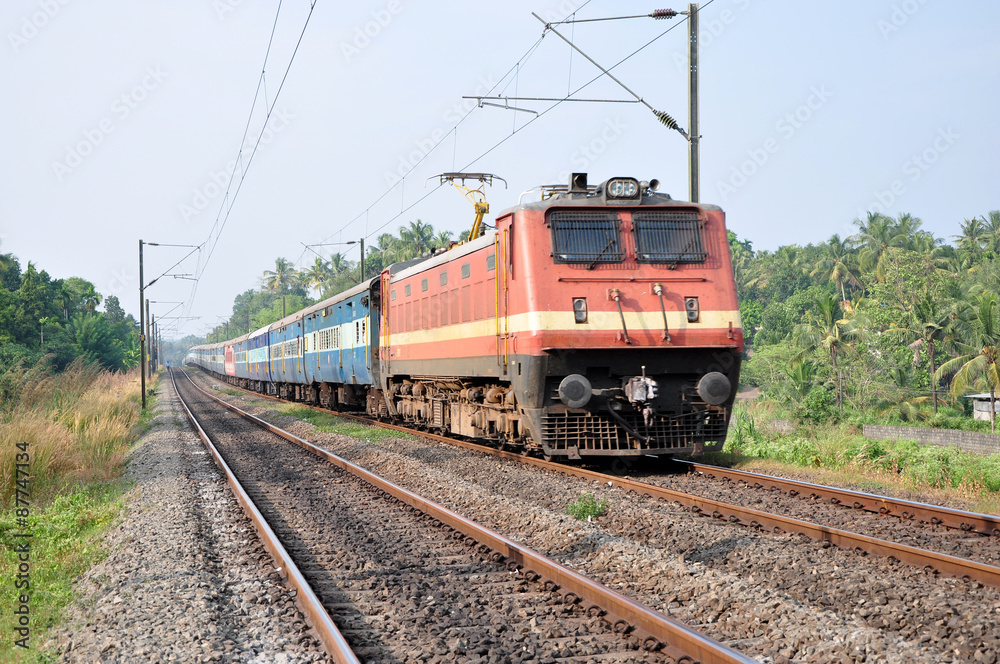 A passenger train being hauled by an electric locomotive in Kerala, India.