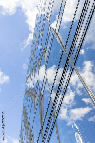 sky and clouds mirroring in a glass facade
