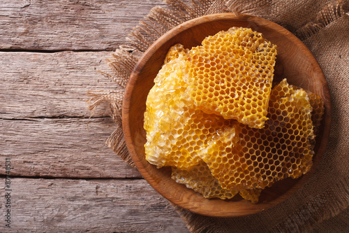 Golden honeycombs on a wooden plate. Horizontal top view
