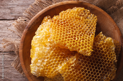 Golden honeycombs on a wooden plate. Horizontal top view closeup
 photo