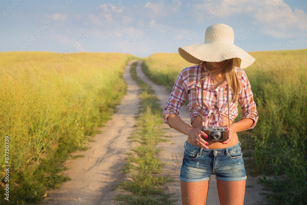Outdoor portrait of young  attractive woman with retro camera