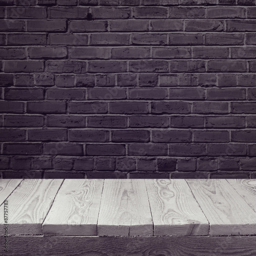 Empty wooden board background over black brick wall