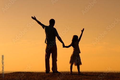 Father and daughter gretting the sunset