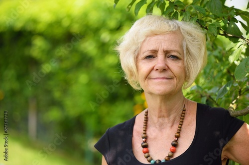 Obraz na płótnie Mature, blonde woman in garden, w salonie