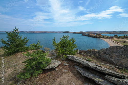 The shore of Lake Baikal, with green trees and large stones