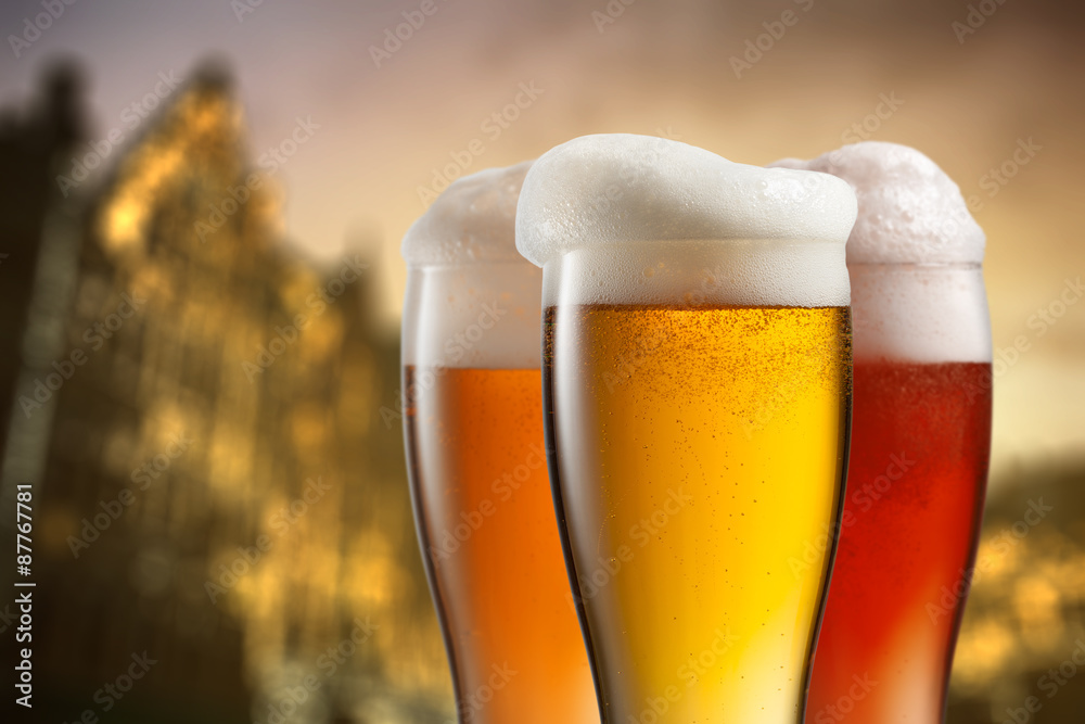 Glasses of beer against blurred european city Glasses of beer against blurred european city