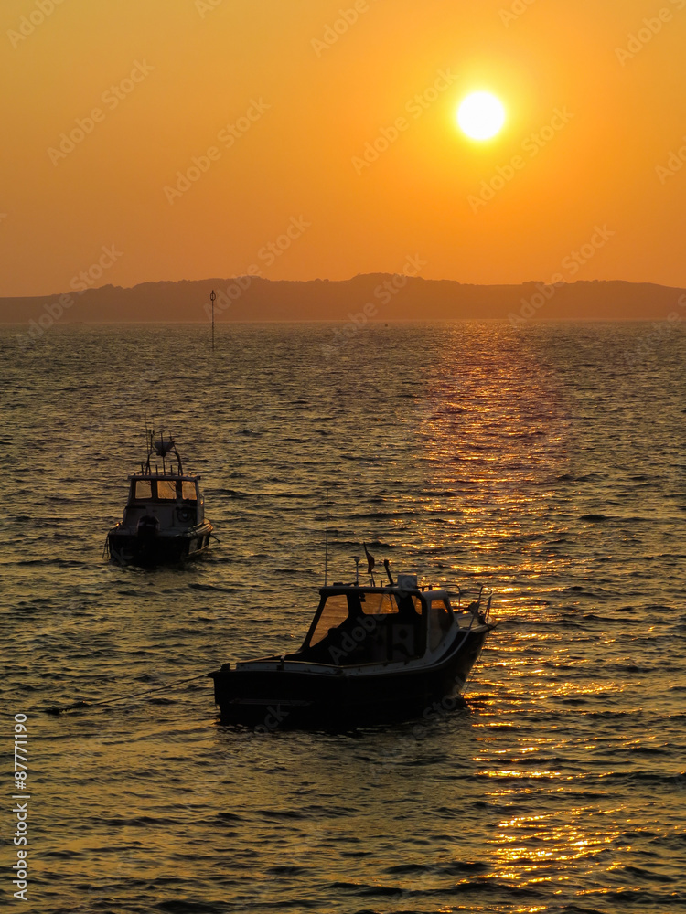 Fishing boats in a bay at sunset