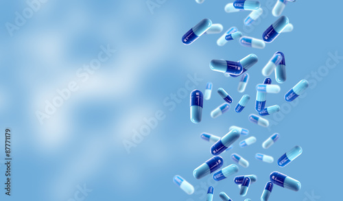 Falling medical pills on blue background