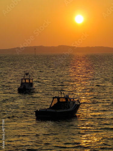 Fishing boats in a bay at sunset